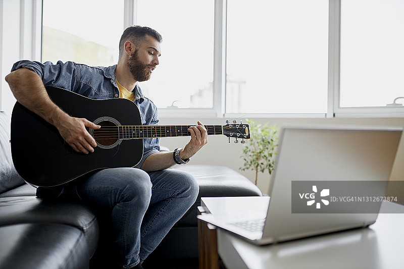 在客厅里进行视频通话的原声吉他图片素材