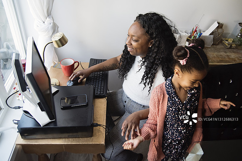 在狭小空间在家工作，孩子试图偷手机的女人图片素材