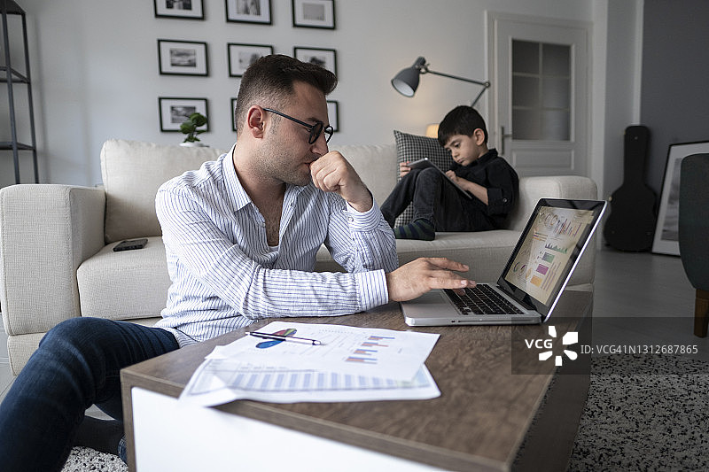 隔离期间用笔记本电脑居家办公的男人图片素材