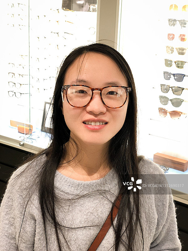 年轻女子试戴新眼镜图片素材