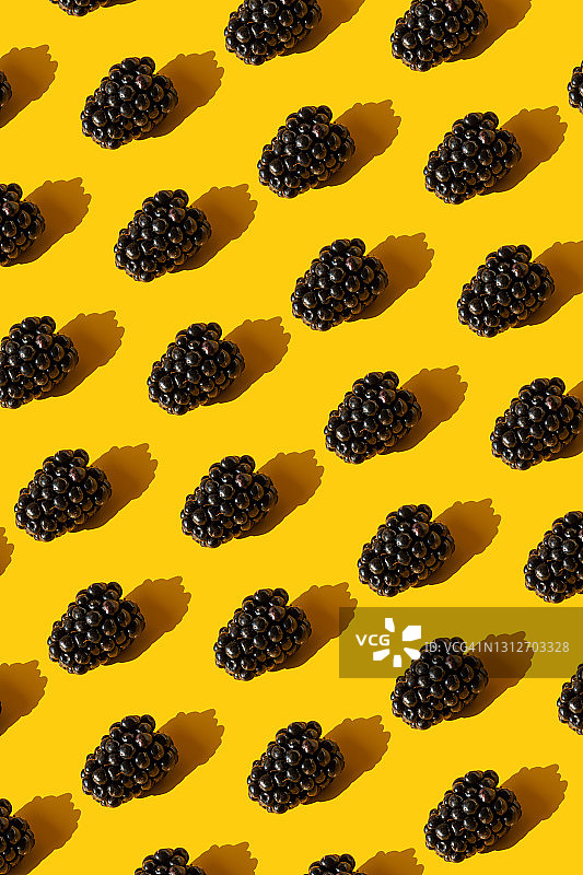 黄色背景上的重复黑莓图案图片素材