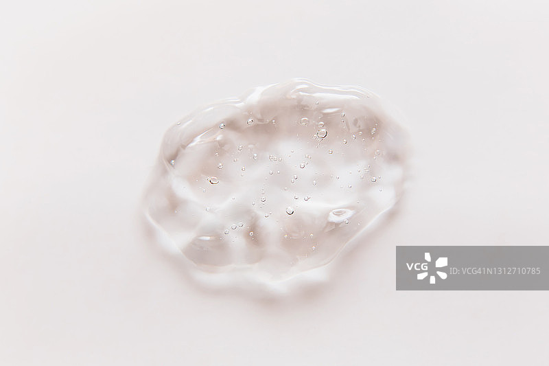 白色背景上的透明凝胶滴。透明质酸液体凝胶。平铺，俯视，复制空间图片素材