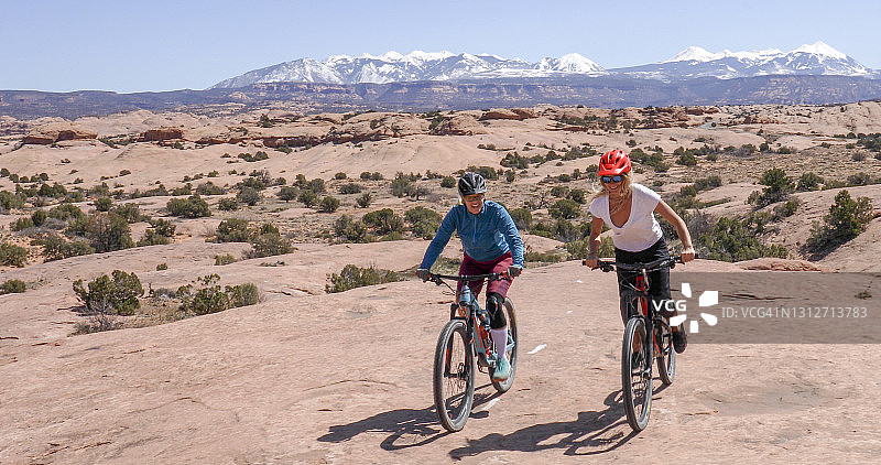骑山地自行车的女人在早上攀登斯利克罗克步道图片素材
