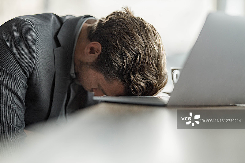 过度劳累的商人在电脑上小睡图片素材