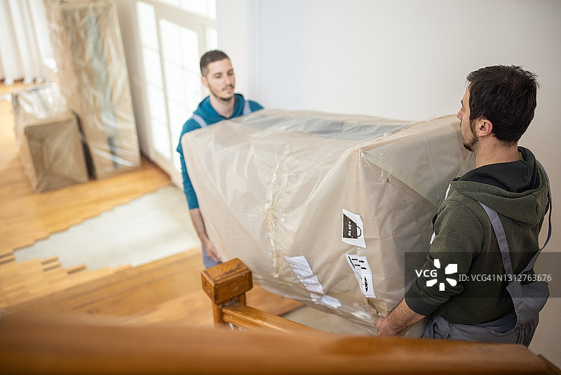 专业搬运工将新家具搬进屋内图片素材