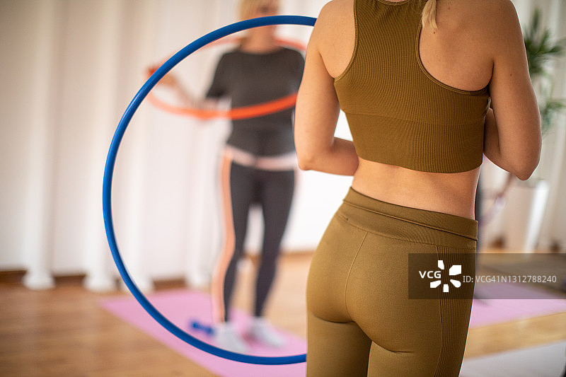 有氧运动教练和老年人在有氧运动课上练习呼啦圈图片素材