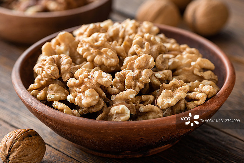 木桌上的棕色碗装核桃图片素材