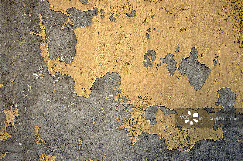 灰色混凝土墙上剥落的黄色油漆图片素材