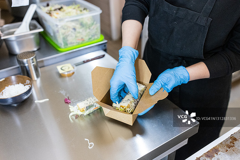 厨师将越南春卷打包进食品包装图片素材