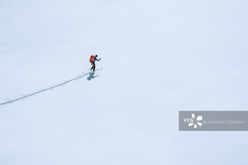 在海岸山脉，滑雪者在覆盖着厚厚积雪的冰川上开辟新路线的鸟瞰图图片素材