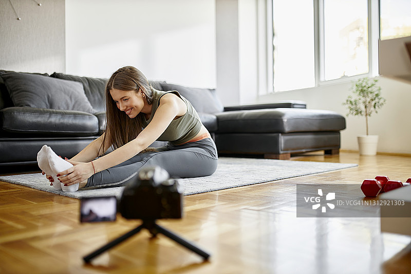 年轻女人在家用相机录制在线视频进行在线培训图片素材