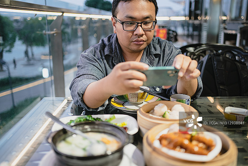 拍摄美食的超重男人图片素材