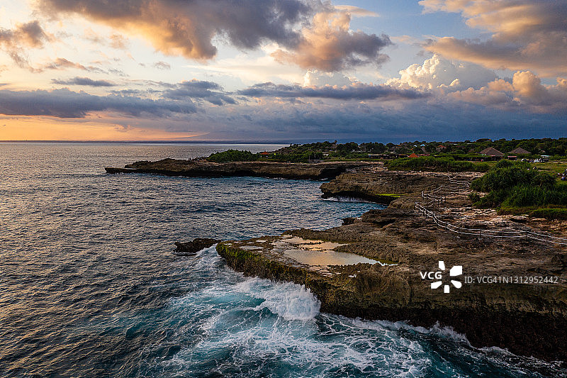 巴厘岛努沙蓝梦岛崎岖海岸的壮丽日落图片素材