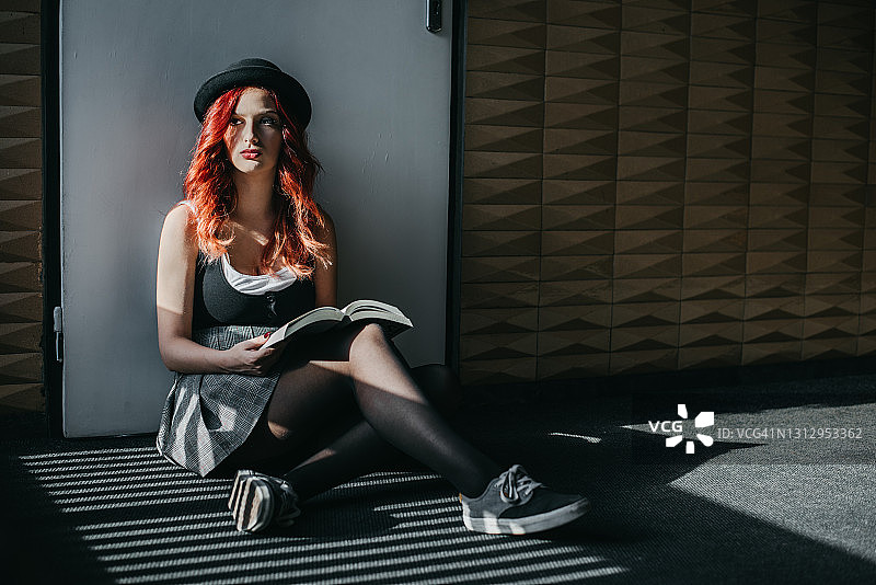 红发女人在地板上阅读图片素材