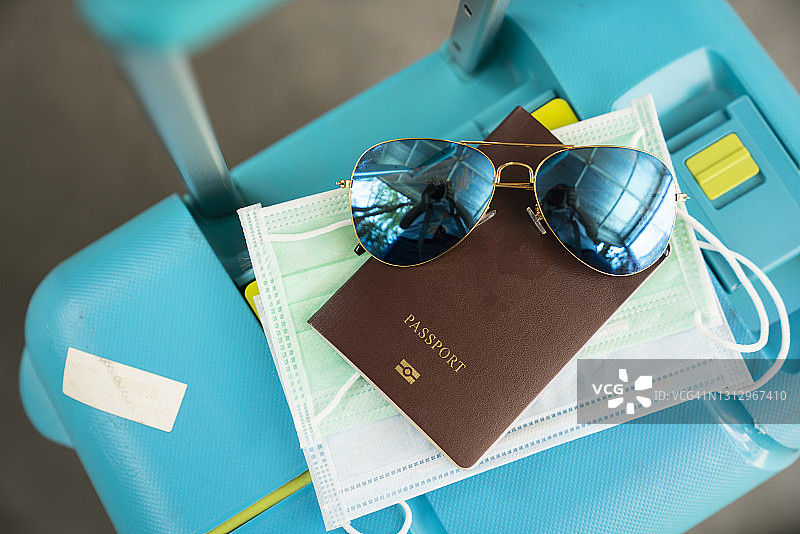 COVID-19旅行口罩、护照和行李图片素材