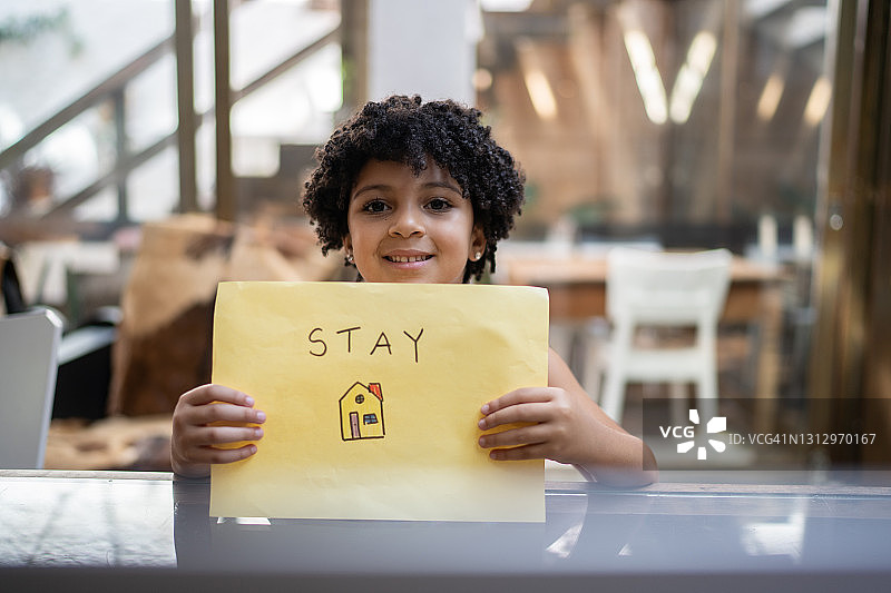 女孩手持“居家”字样纸张图片素材