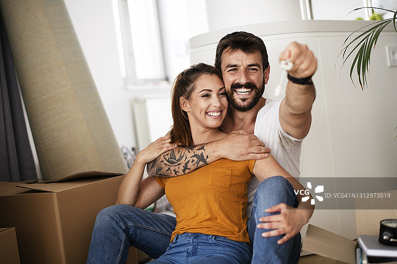 情侣拿着他们新房的钥匙图片素材