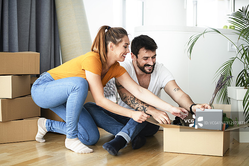 快乐的年轻夫妇正在打开他们的行李。库存照片图片素材