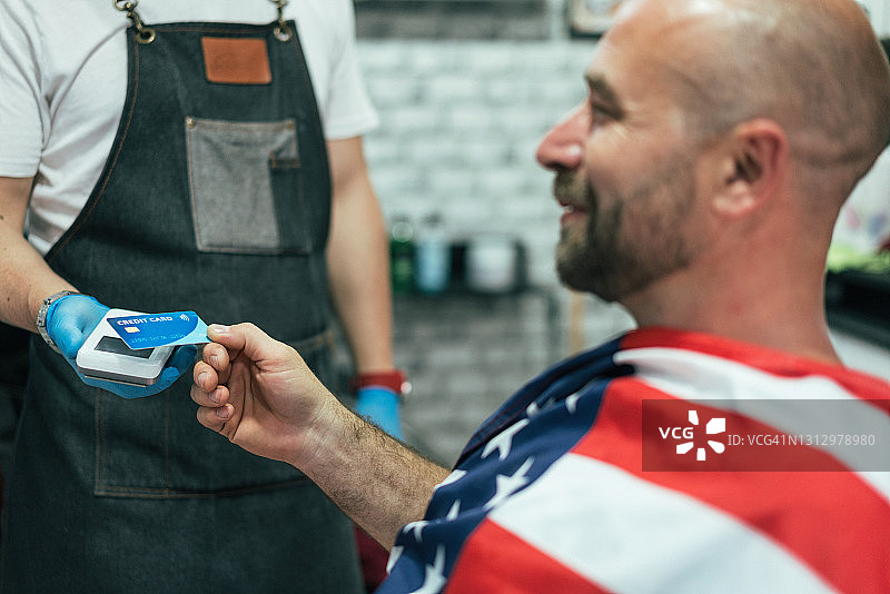 男人在理发店非接触式支付图片素材