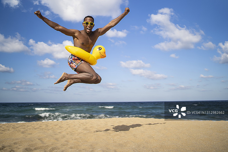 在空旷海滩上跳跃的年轻巴西男人图片素材