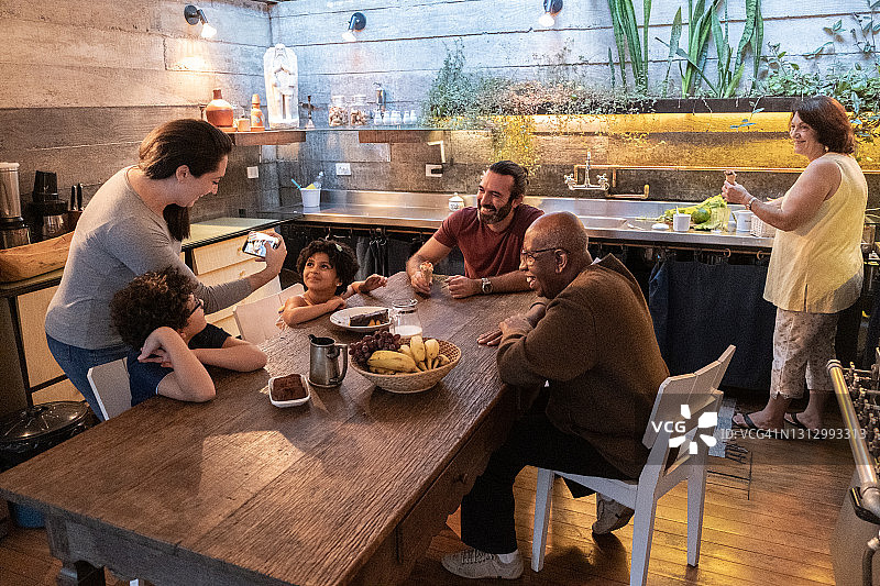 一家人在厨房重聚，在家使用手机图片素材