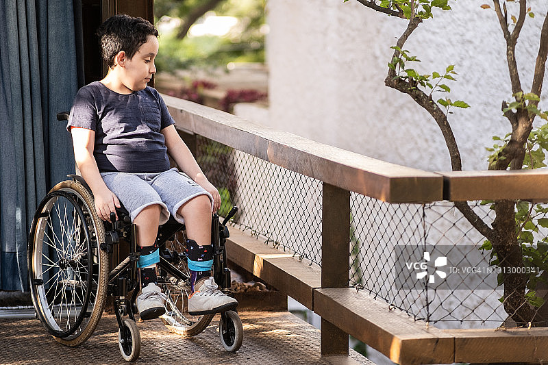 户外房屋上的轮椅男孩图片素材