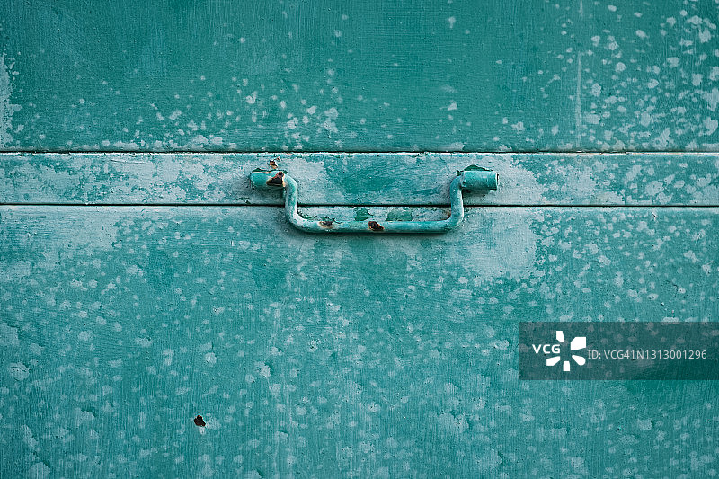 绿色金属门把手的特写，门因年代久远而生锈图片素材