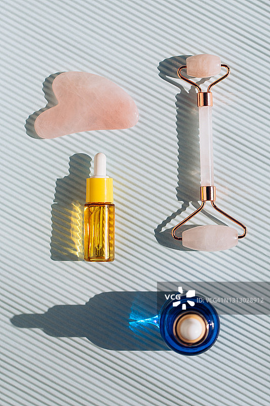 玻璃瓶、玫瑰石英滚轮和刮痧板图片素材