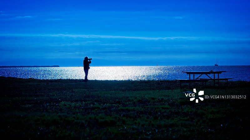 在蓝色时刻工作的孤独摄影师图片素材
