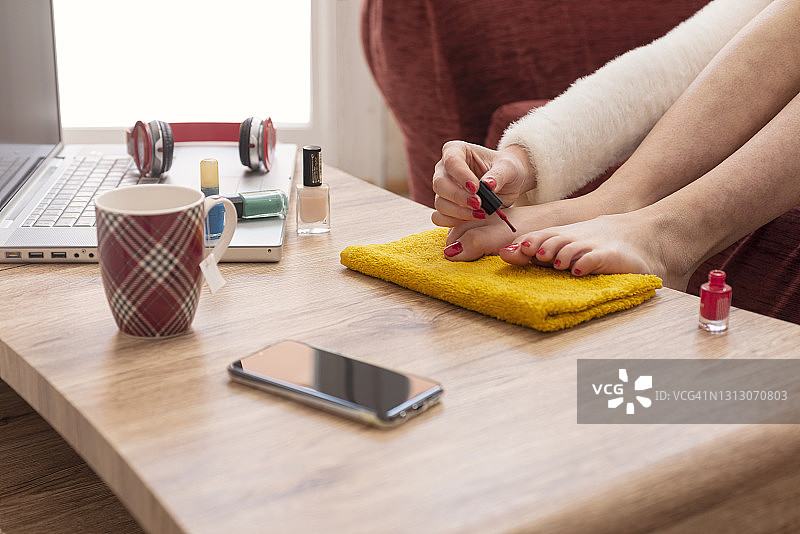 女人在脚趾上涂指甲油图片素材