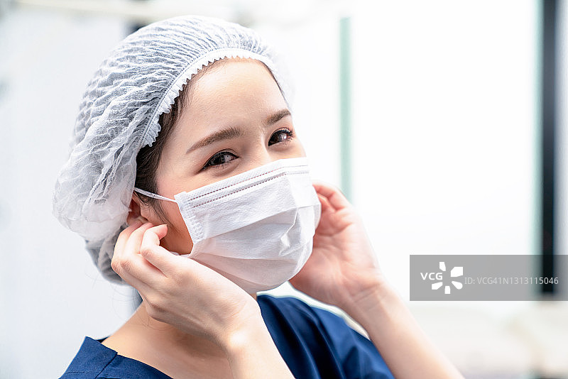 戴外科口罩穿防护服的女医生肖像图片素材