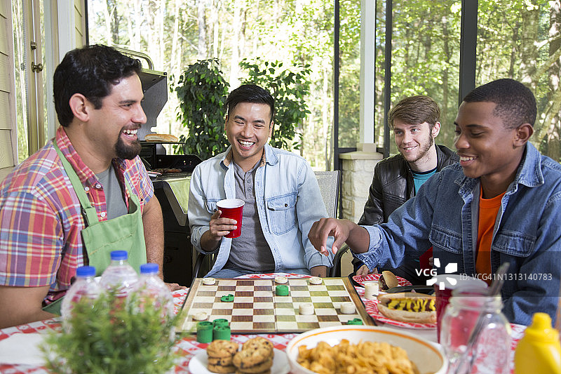 不同种族的年轻男子在户外聚餐图片素材