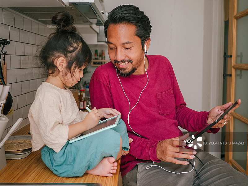 亚洲时尚男子在家使用平板电脑图片素材