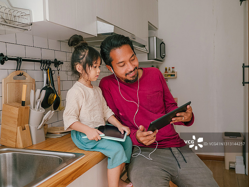 亚洲时尚男子在家使用平板电脑图片素材