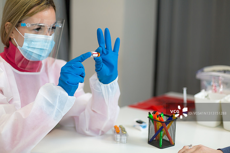 年轻女医护人员向病人展示一种新的新冠肺炎疫苗图片素材