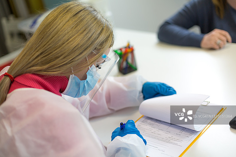 女护士为患者准备新冠疫苗医疗同意书图片素材