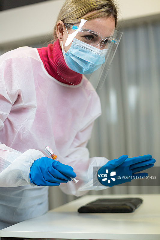 年轻女医务人员从药瓶中抽取新冠疫苗图片素材
