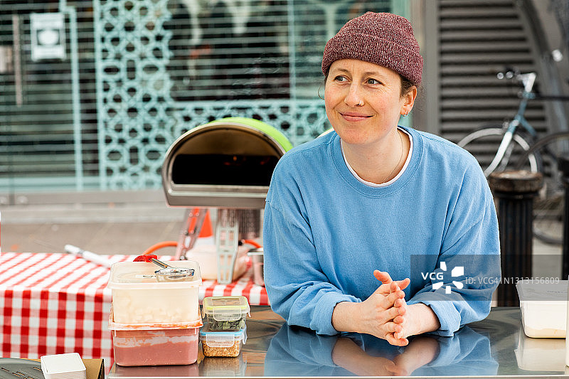 一位年轻人在户外市场经营披萨摊位图片素材