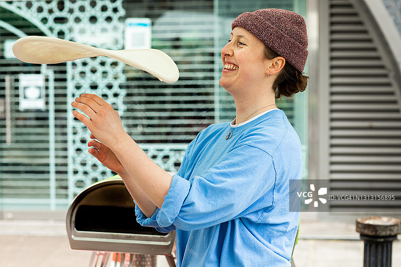 一位年轻人在户外市场经营披萨摊位图片素材