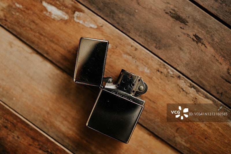 木桌上的复古金属防风打火机图片素材