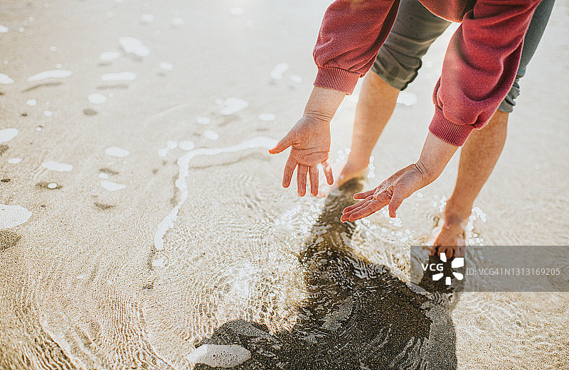 小女孩划水并伸手感受手中的水图片素材