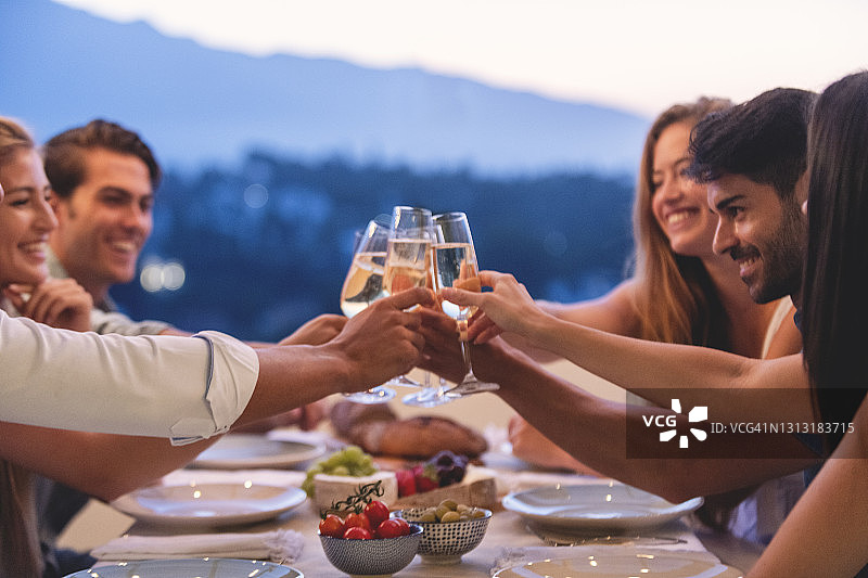 朋友们在日落时分举杯庆祝图片素材
