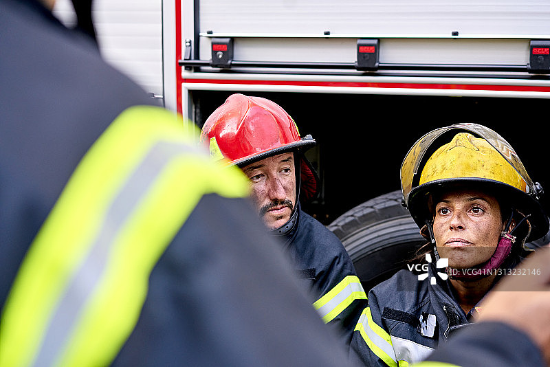 30多岁和40多岁的男女消防员坐在户外图片素材