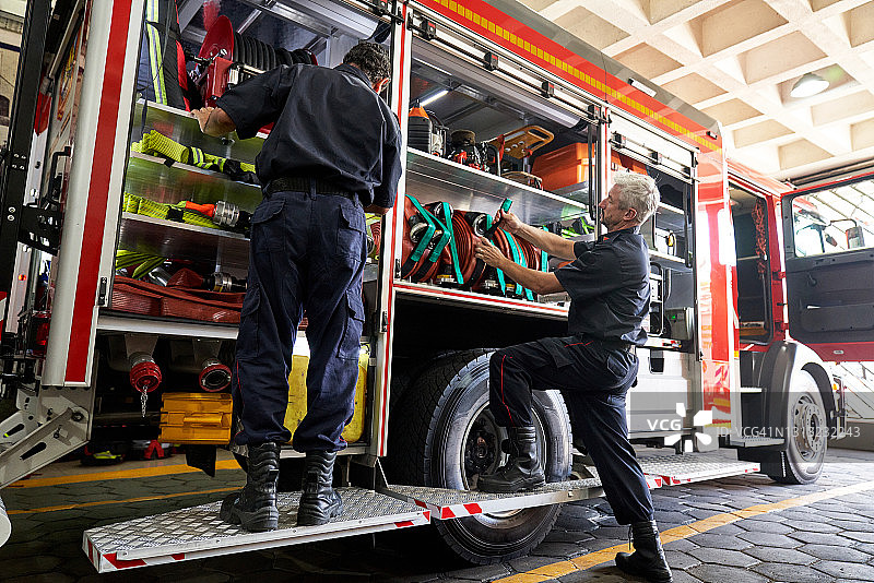 消防员整理消防车储物箱图片素材