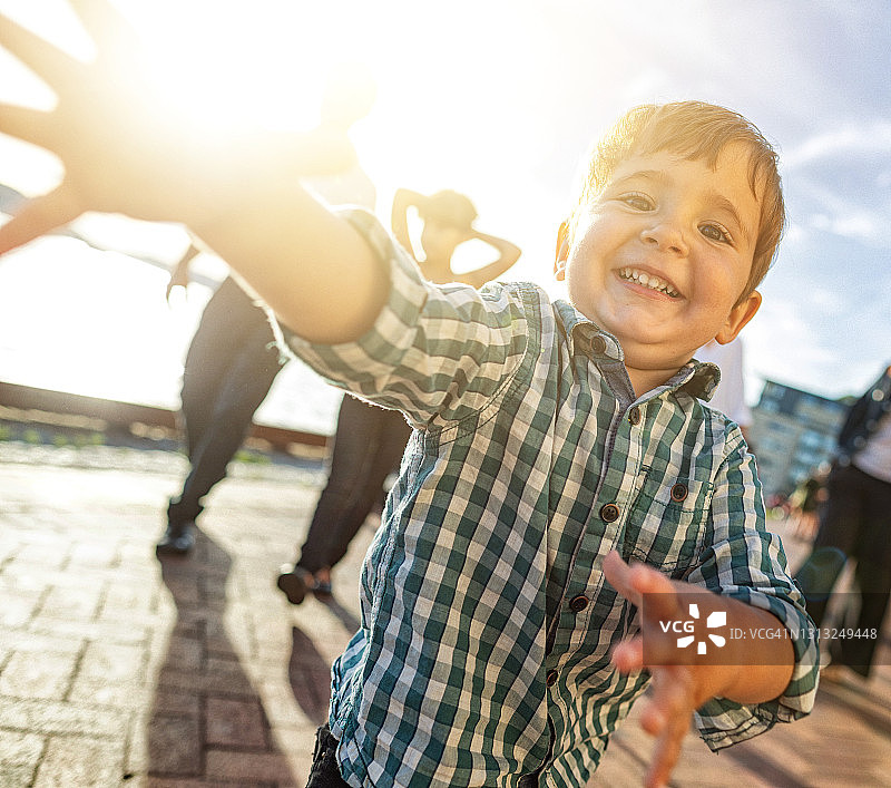 笑容满面地跳入镜头的可爱小男孩图片素材