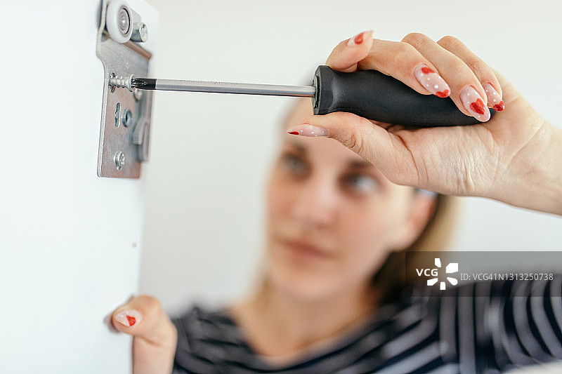 年轻女子独自组装新衣柜图片素材