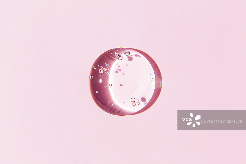 粉色背景上的透明凝胶滴图片素材