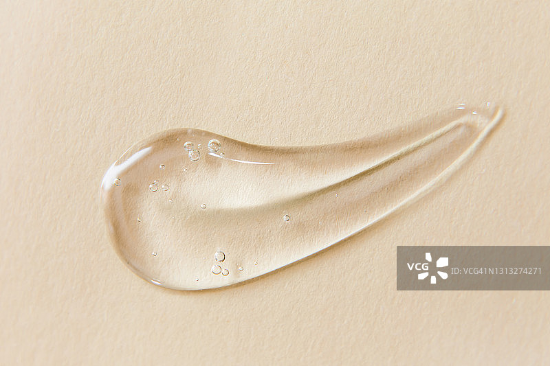 米色背景上的透明凝胶涂抹图片素材