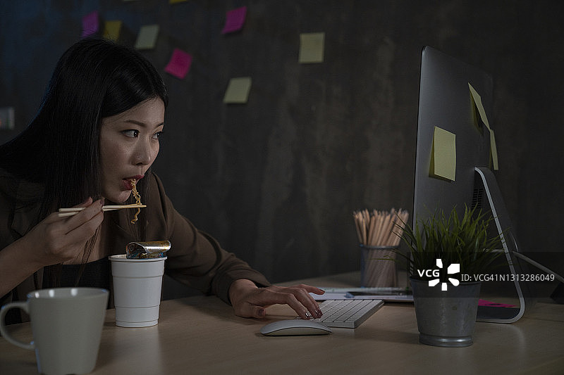 夜晚在卧室里用笔记本电脑工作的女人图片素材