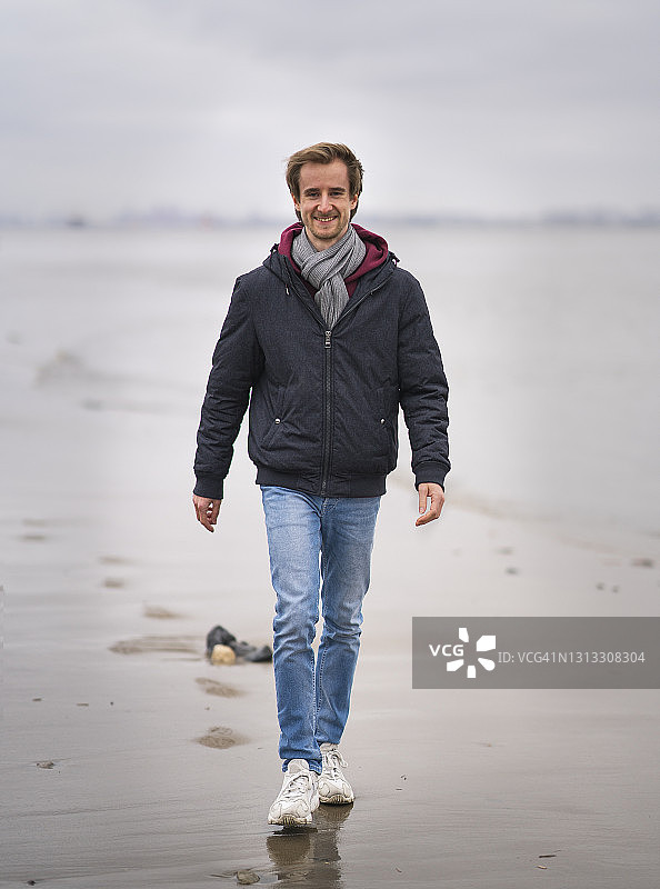 穿牛仔裤的年轻男子沿着易北河岸边行走图片素材